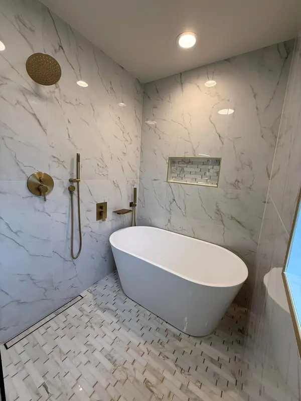 Modern spa-like bathroom renovation in Glendale with stone slab walls and curbless shower